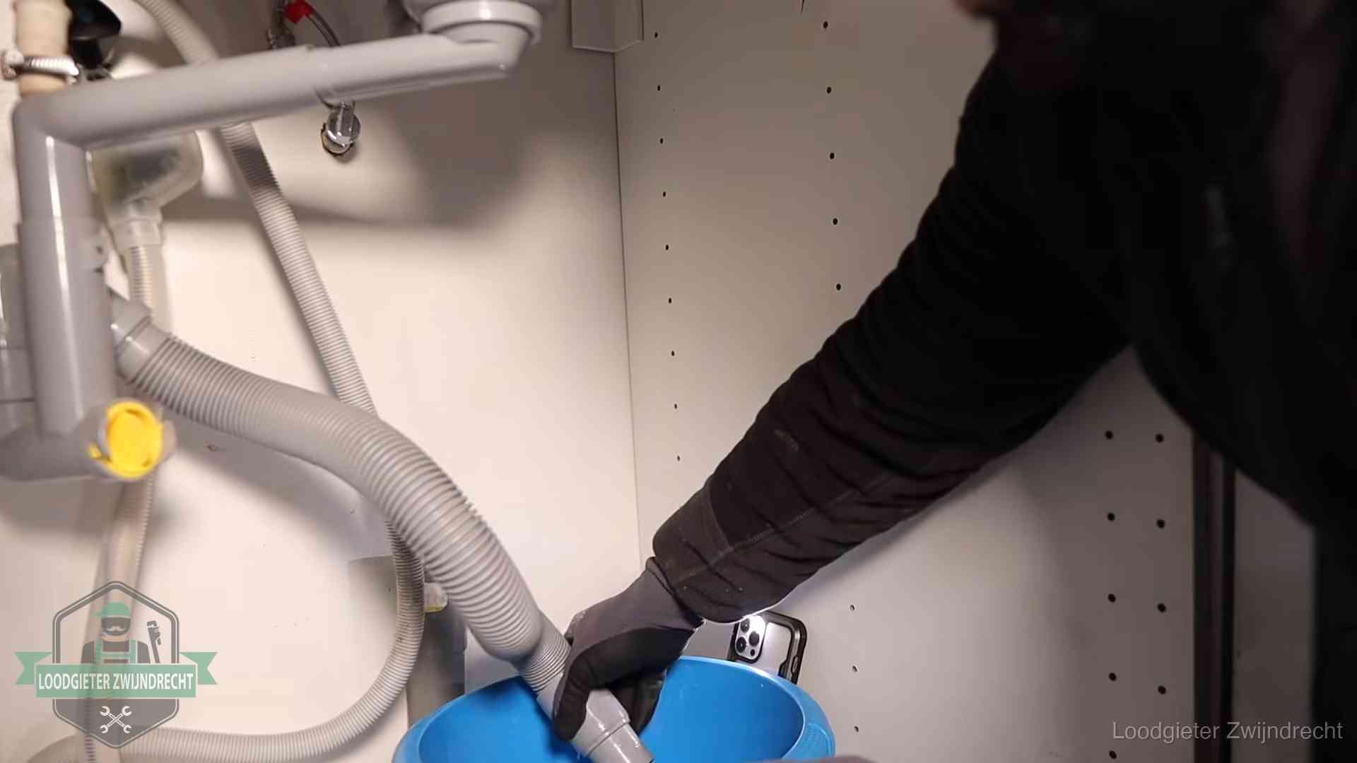 Zelf je afvoer legen in Zwijndrecht Afvoerslang loopt leeg in een emmer onder de gootsteen in Zwijndrecht, een klus die je zelf kunt doen