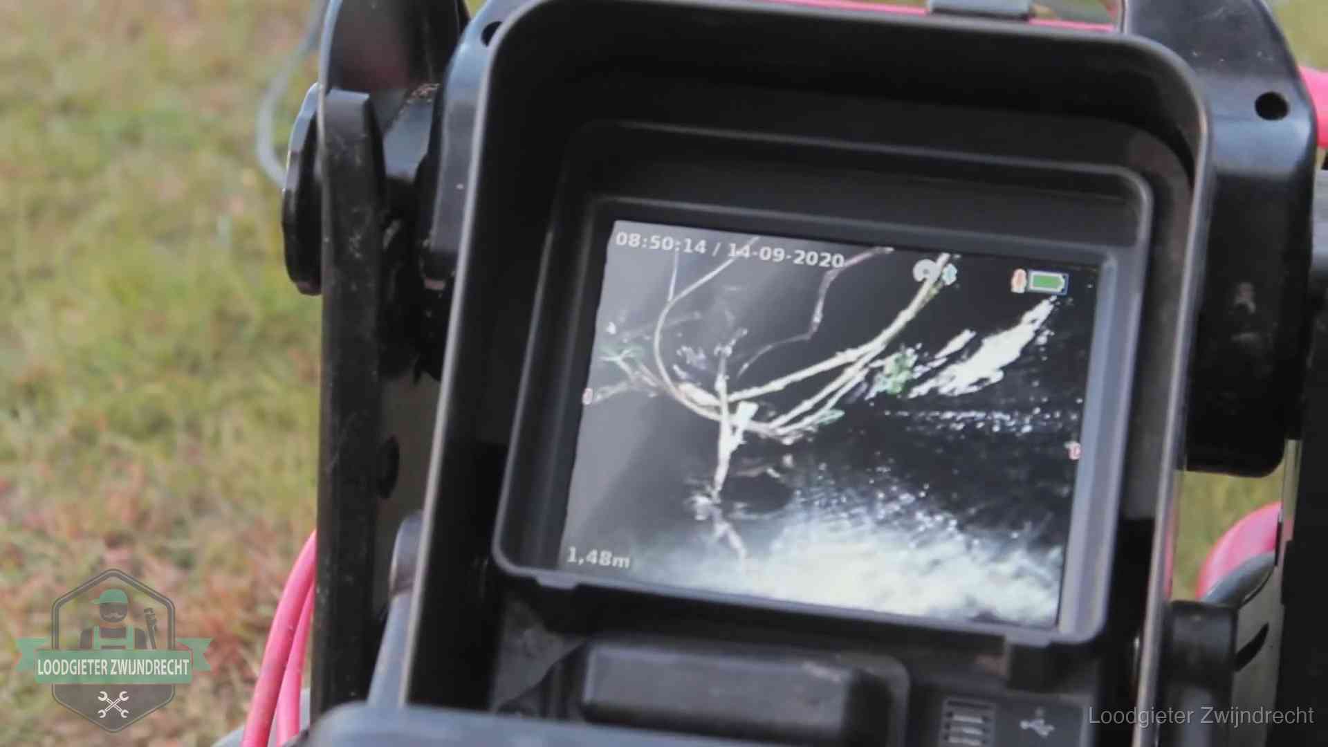 Camera-inspectie van het riool in Zwijndrecht Monitor van een rioolcamera toont wortelingroei in de rioolbuis bij een woning in Zwijndrecht