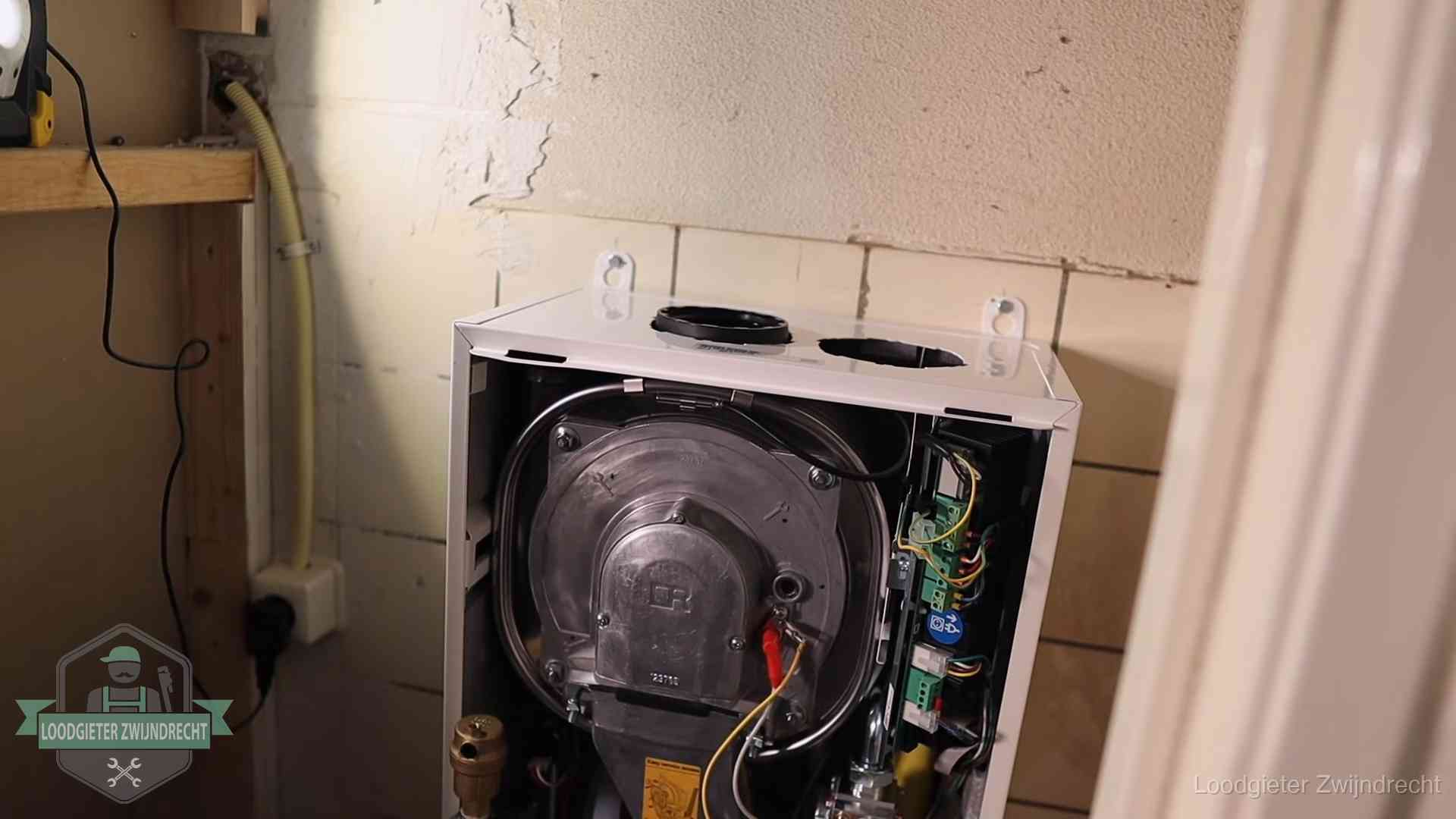 Geopende cv-ketel tijdens een onderhoudsbeurt in Zwijndrecht, met brander en warmtewisselaar zichtbaar