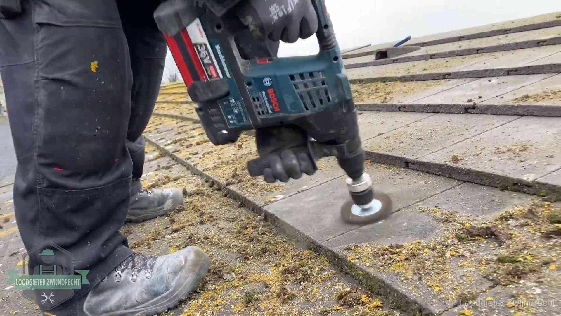 Betonnen dakpannen worden machinaal gereinigd tijdens dakonderhoud in Zwijndrecht