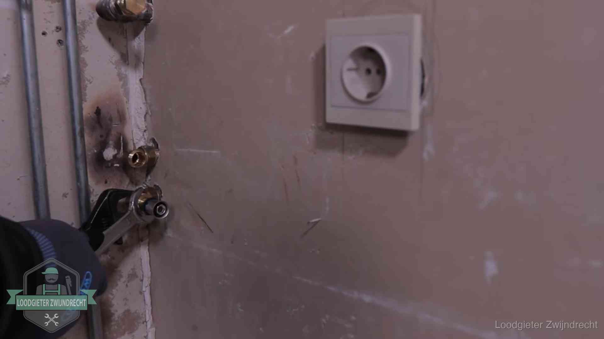 Monteur draait een perskoppeling vast op een leidingaansluiting in Zwijndrecht