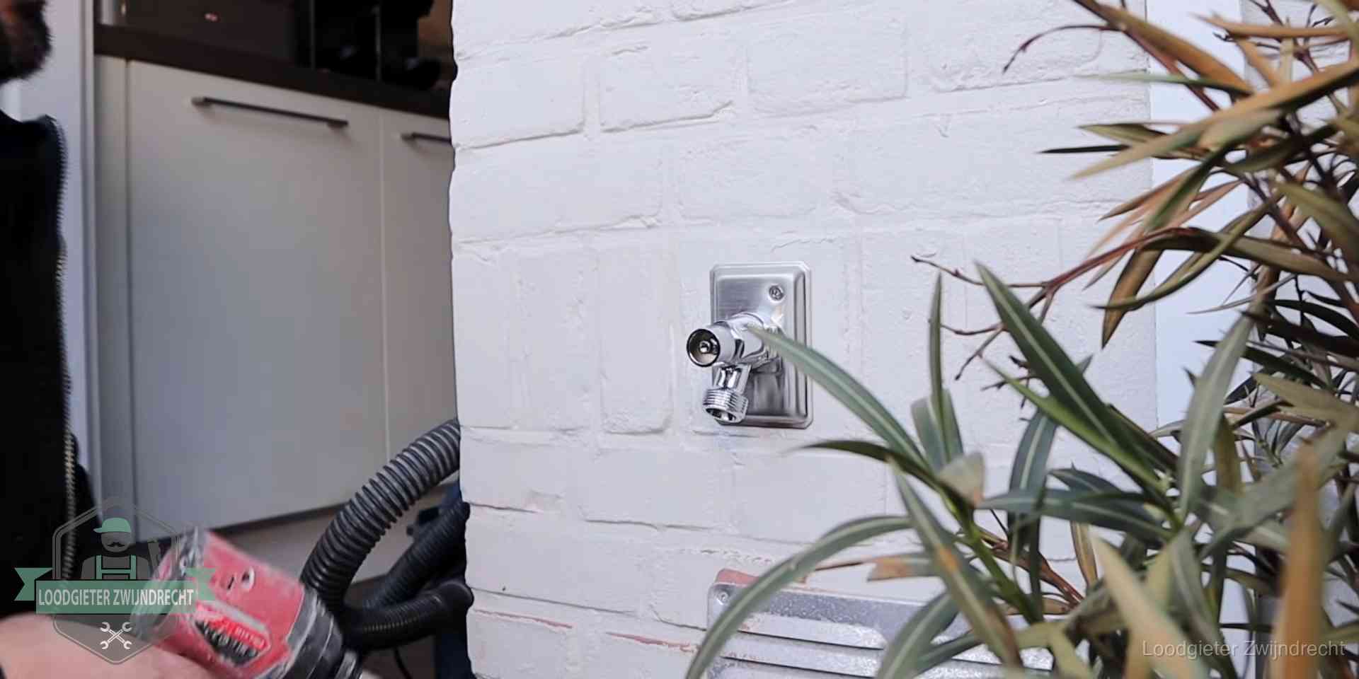 Chromen kraan op een muurplaat bij een woning in Zwijndrecht, dichtdraaien is stap een van de lektest