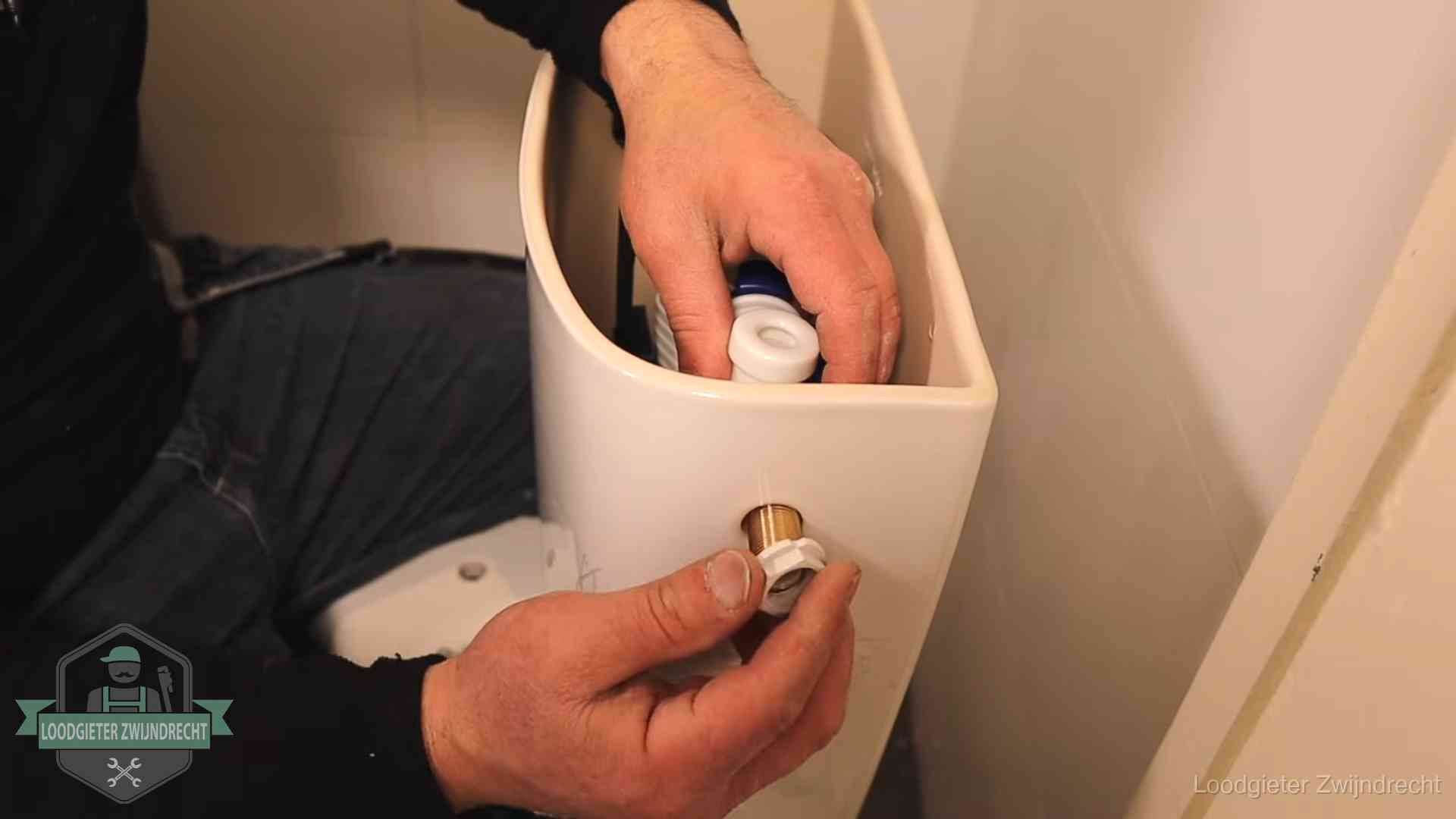 Loodgieter voor je verstopte wc in Zwijndrecht Loodgieter monteert de vlotterkraan van een stortbak bij een toilet in Zwijndrecht