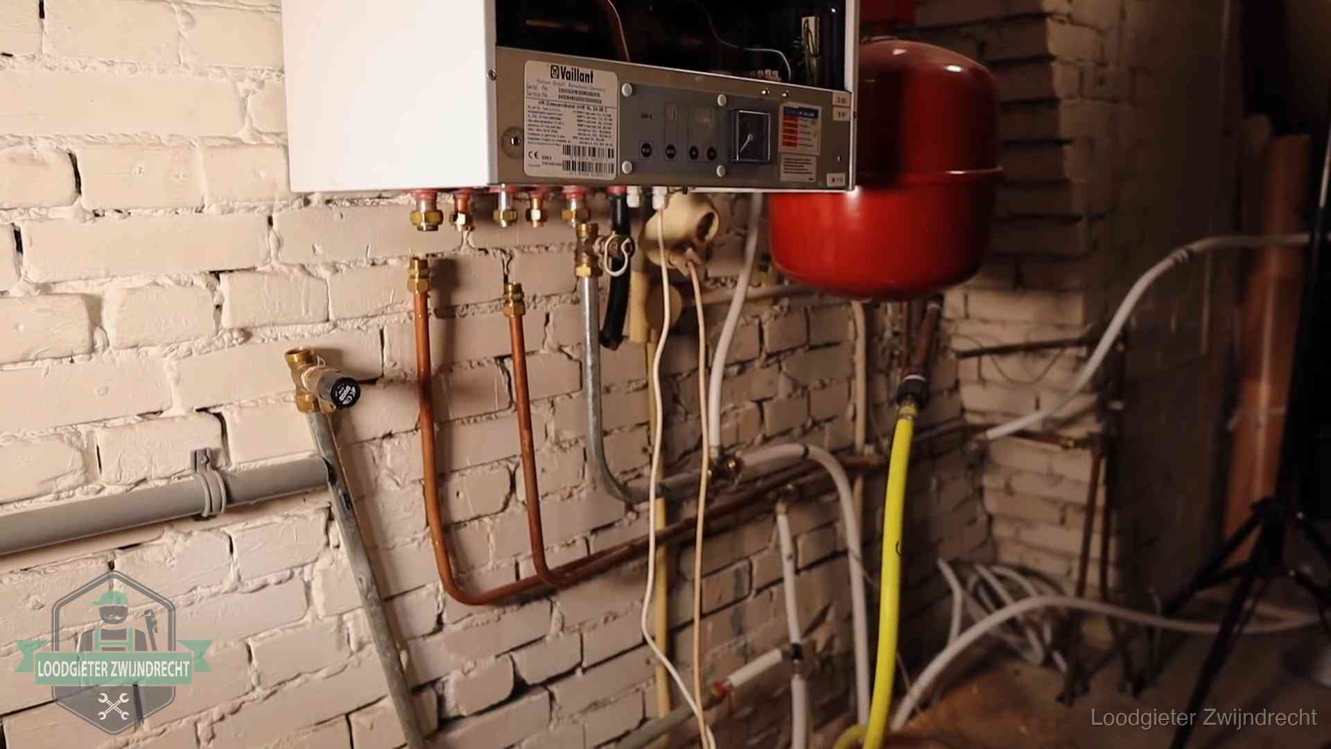 Verouderde cv-ketel met een wirwar van oude leidingen in een woning in Zwijndrecht