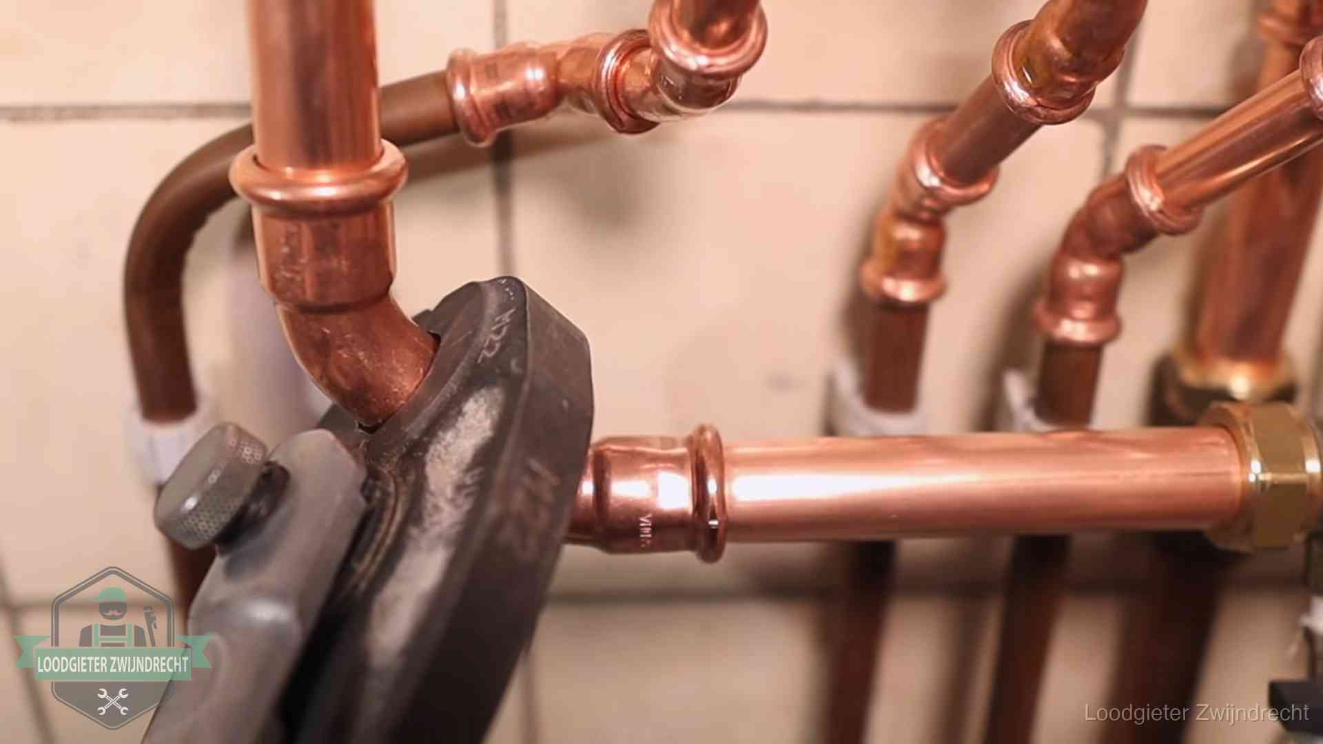 Persmachine perst een koperen fitting op nieuw leidingwerk in Zwijndrecht
