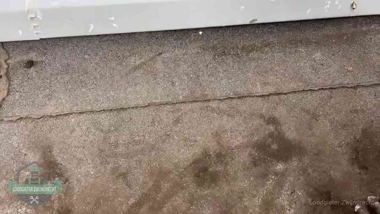 Vochtplekken bij de naad van een plat dak na aanhoudende regen in Zwijndrecht