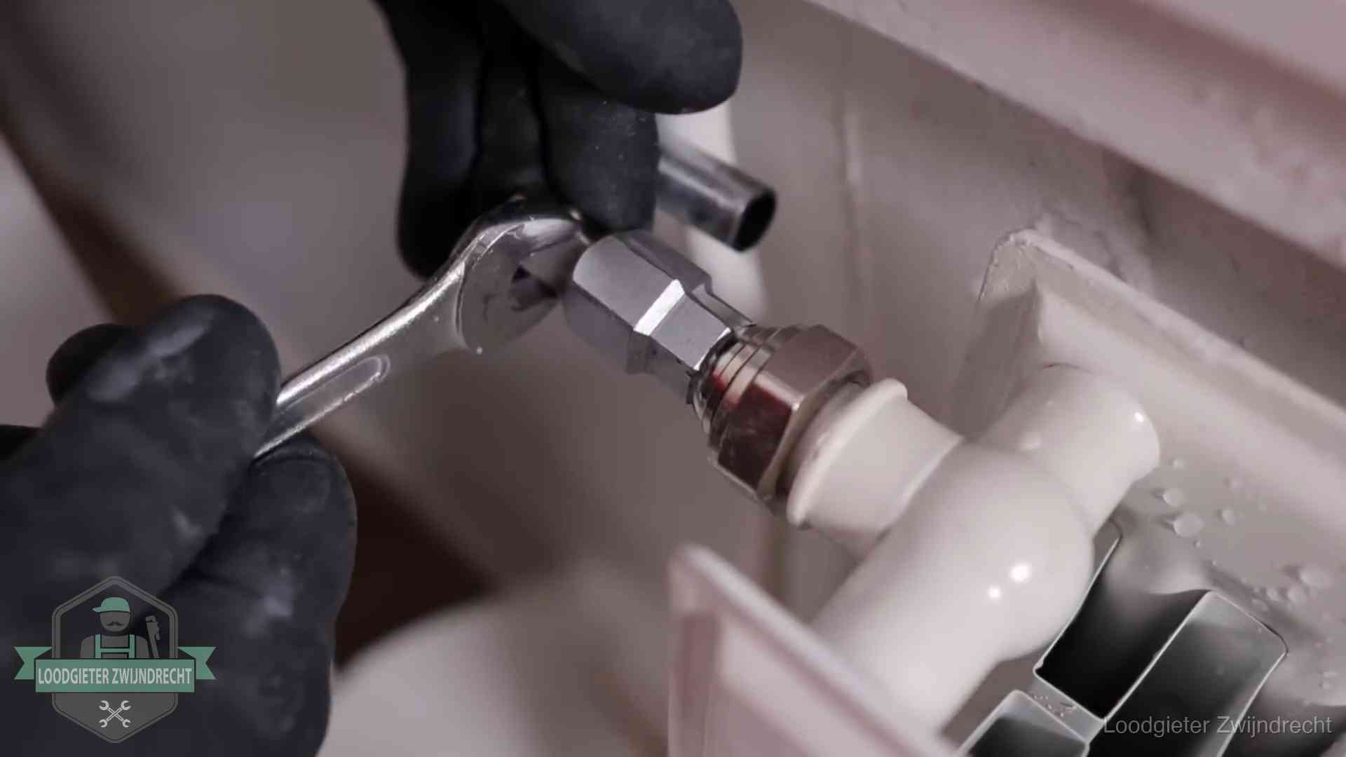 Steeksleutel draait een wartelkoppeling op een radiatorkraan aan in Zwijndrecht