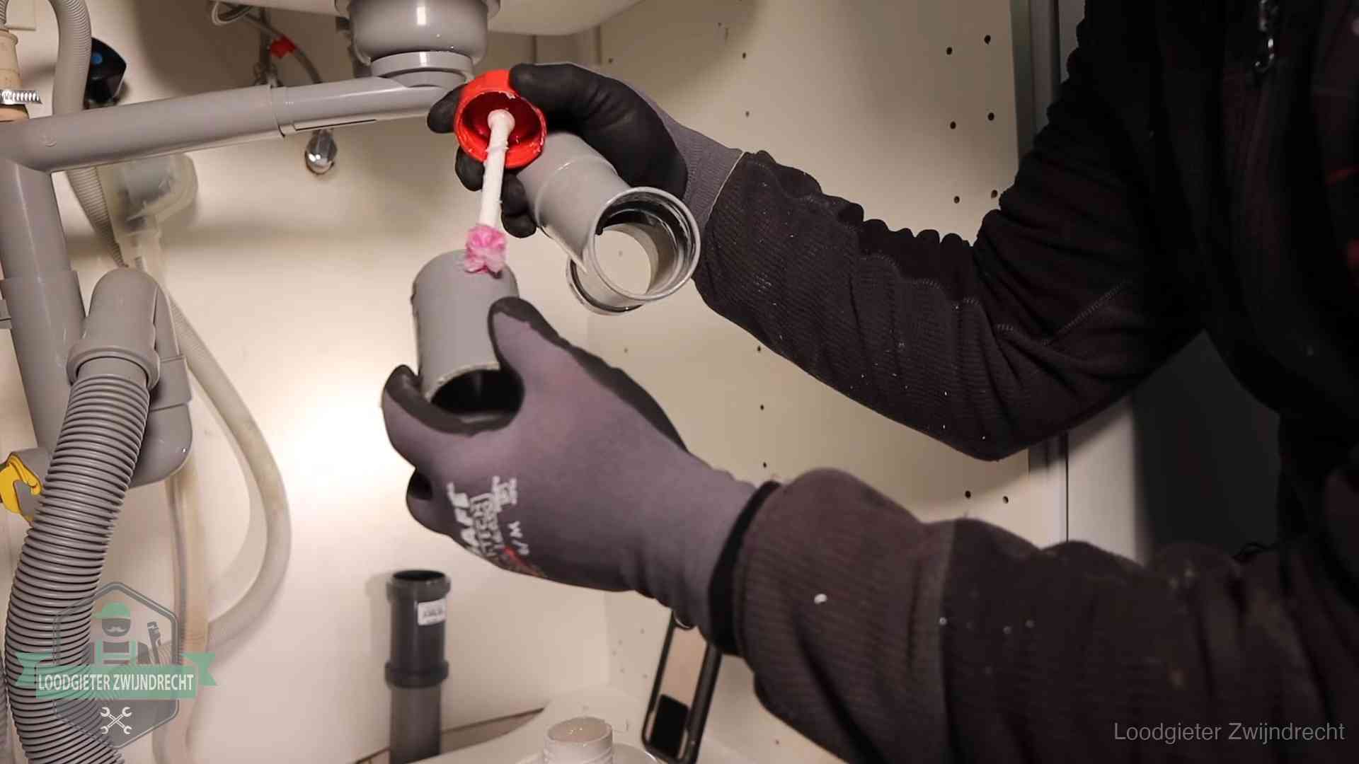 Oorzaak van een verstopte afvoer in Zwijndrecht Loodgieter demonteert en reinigt de sifon onder een keukenkast in Zwijndrecht