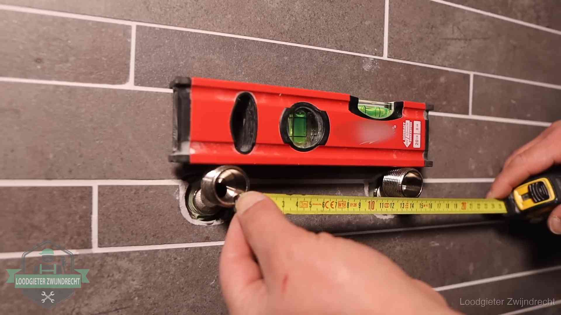 Waterpas en duimstok bij kraan-aansluitpunten in een badkamer in Zwijndrecht