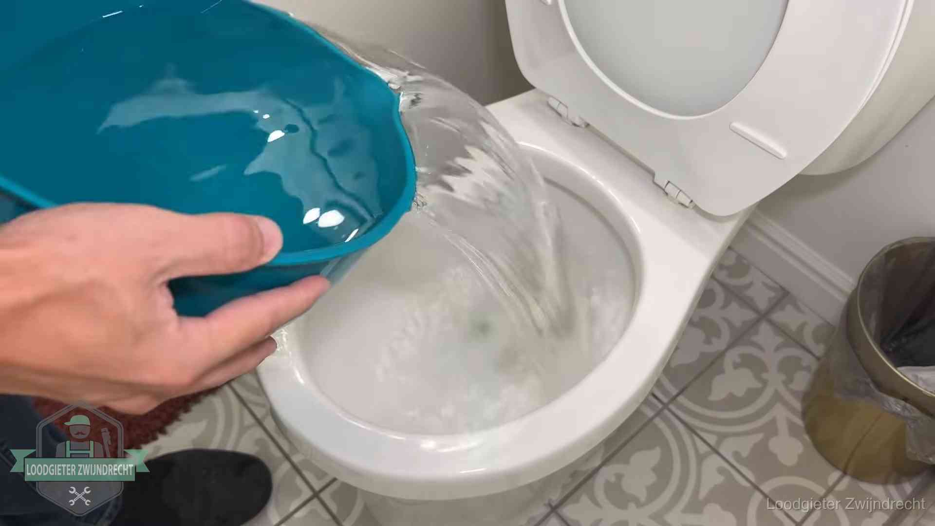 De warm-water-methode in Zwijndrecht Warm water wordt voorzichtig in de wc-pot gegoten in Zwijndrecht
