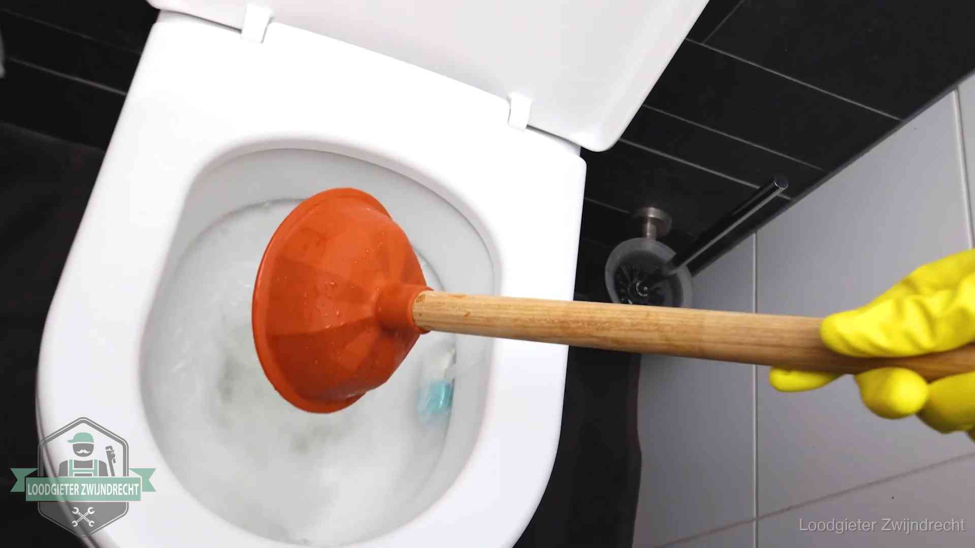 Wc ontstoppen met de plopper in Zwijndrecht Plopper wordt in de wc-pot gedrukt bij het ontstoppen van een toilet in Zwijndrecht