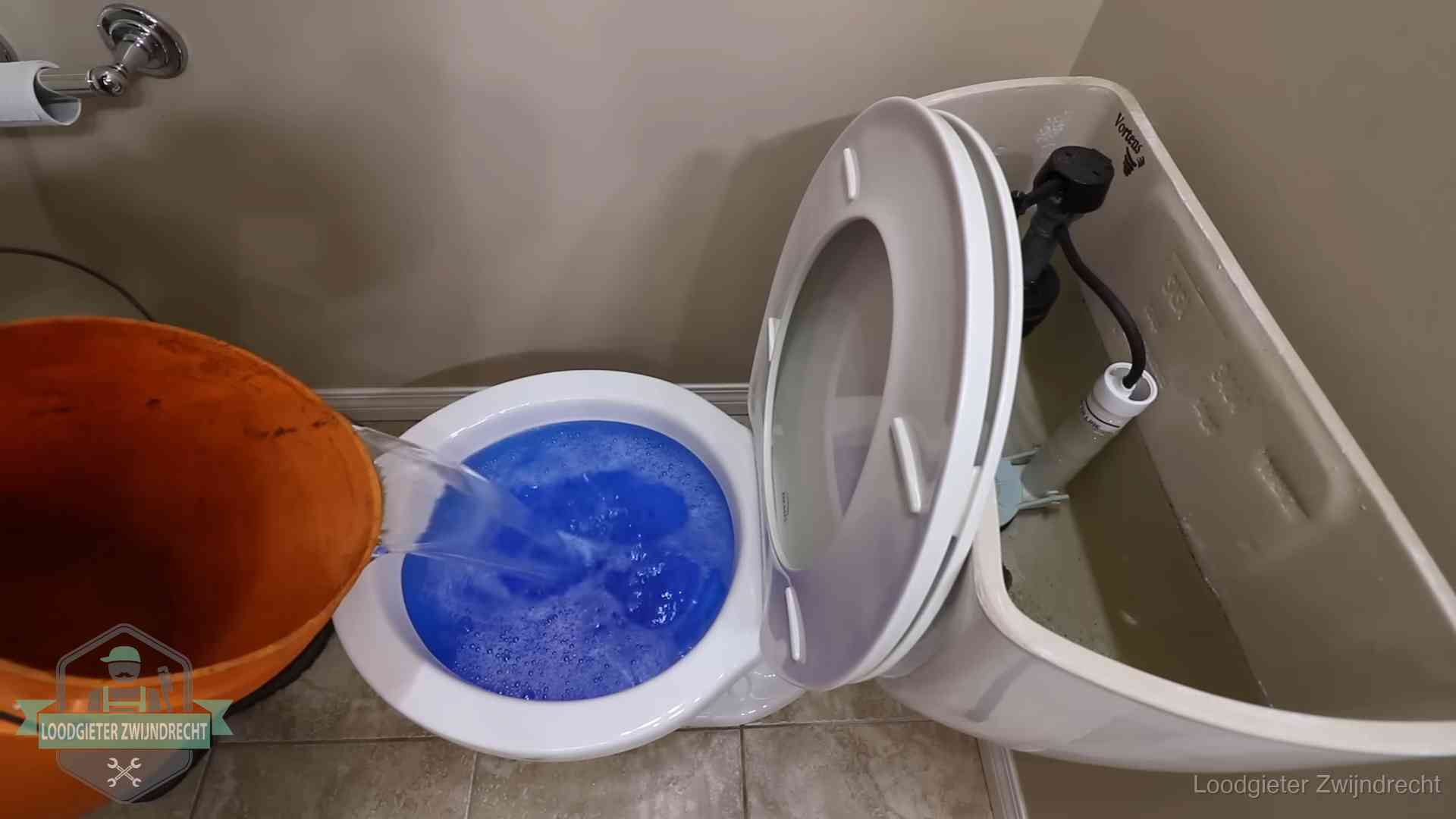 Water komt omhoog in de wc in Zwijndrecht Water bij de wc-pot wordt met een emmer weggewerkt om schade te beperken in Zwijndrecht